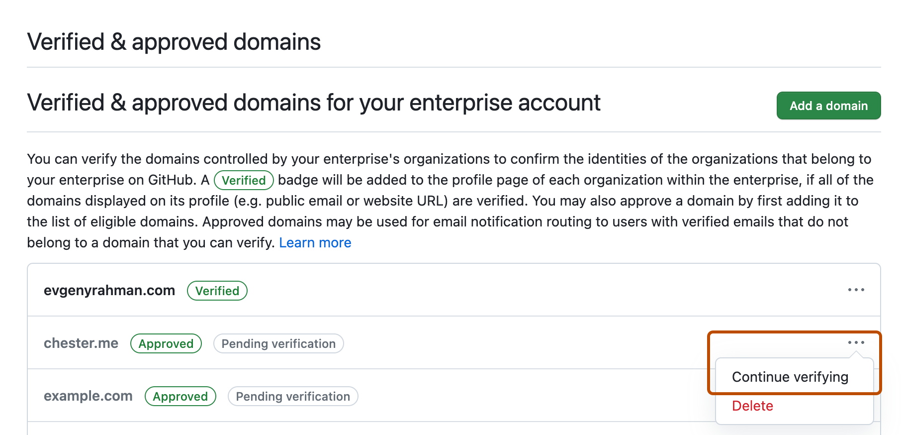 Captura de tela da lista de domínios verificados e aprovados para sua empresa. Um menu suspenso rotulado com três pontos é expandido e realçado com um contorno laranja, juntamente com a opção "Continuar verificando domínio".